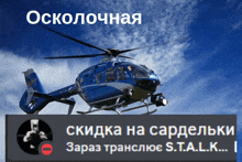 a blue and white helicopter is flying in the sky above a sign that says s.t.a.l.k.