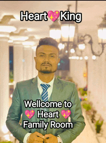 a man in a suit and tie is standing in front of a sign that says heart king