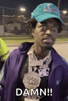 a man wearing a purple jacket and a hat says " damn "