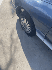 a car with a flat tire is parked on the sidewalk