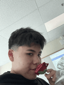 a young man smells a red rose in front of a whiteboard that says google classroom ms