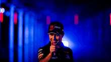 a man wearing a red bull hat giving the thumbs up sign