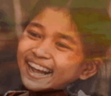 a close up of a child 's face smiling and laughing .