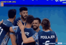 a group of volleyball players are hugging each other and one of them has the name poglaven on the back of his jersey .