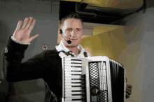 a man wearing a microphone playing an accordion