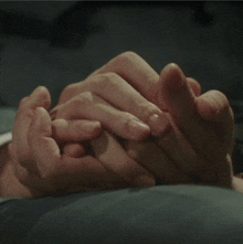 a close up of a person holding another person 's hand .