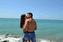 a man and a woman are kissing on a beach