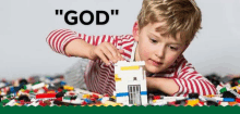 a young boy is playing with a lego house on the floor .