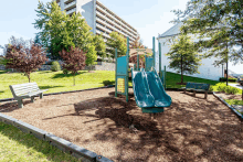 a playground with a slide and a bench in front of a building