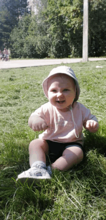 a baby wearing a white hat and a pink shirt that says " everyday "