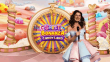 a woman stands in front of a wheel that says sweet bonanza