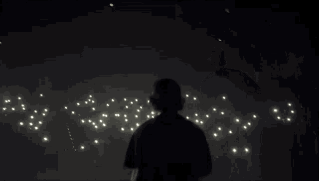 a man is standing on a stage in front of a crowd of people holding a microphone .