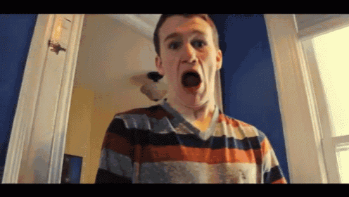 a man wearing a striped shirt is making a funny face