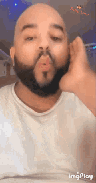 a man with a beard is blowing a kiss with the words baby boop in the corner