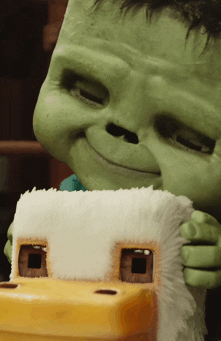 a close up of a green monster holding a toy house