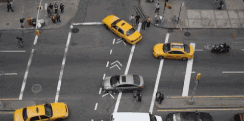 an aerial view of a busy city street with taxis and a car that has the word taxi on it