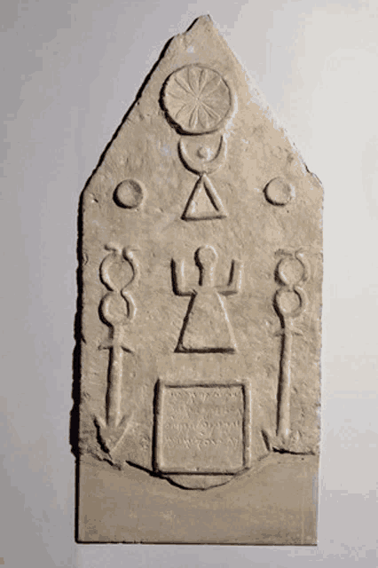 a stone plaque with a triangle and a circle carved into it