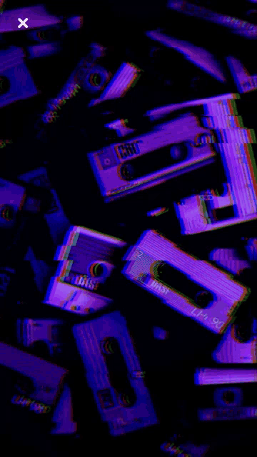 a bunch of cassette tapes are stacked on top of each other in a dark room .