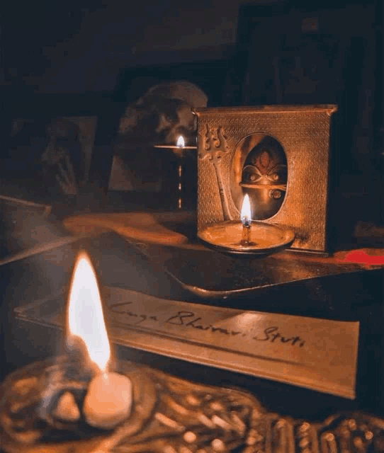 a candle sits on a table next to a piece of paper that says ' longa bharati bruti '