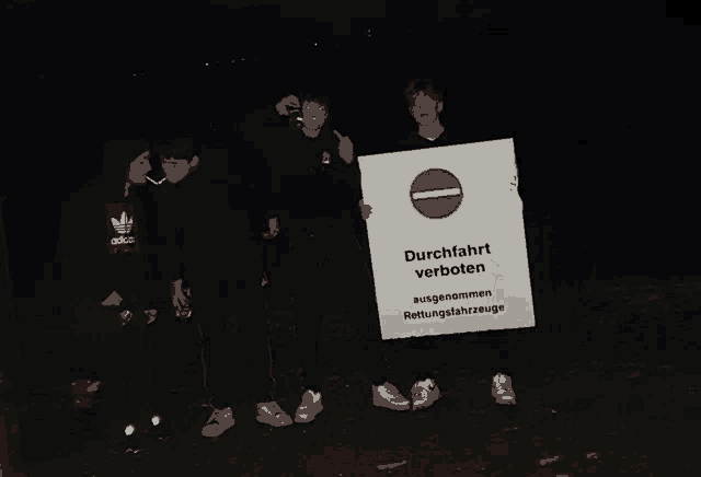 a group of people holding a sign which says durchfahrt verboten