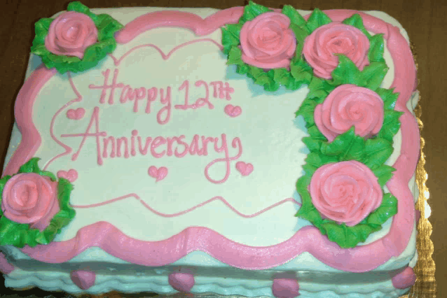 a cake that says happy 12th anniversary with pink roses