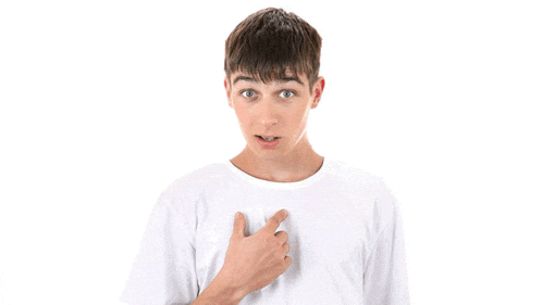 a young boy in a white shirt is pointing at his chest