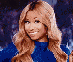 a close up of a woman with blonde hair wearing a blue shirt and smiling .