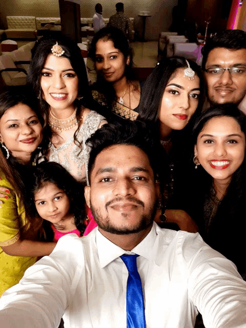 a group of people posing for a selfie including a man in a blue tie