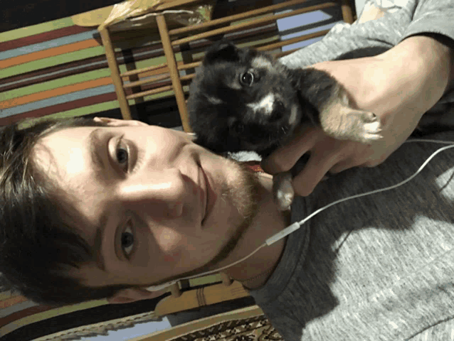 a man wearing headphones is holding a puppy