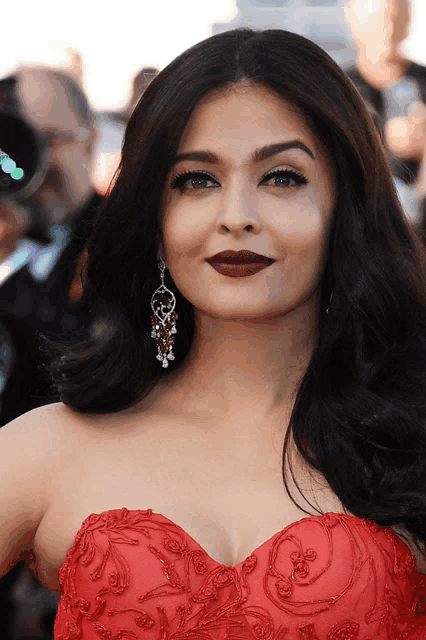 a close up of a woman wearing a red dress and red lipstick