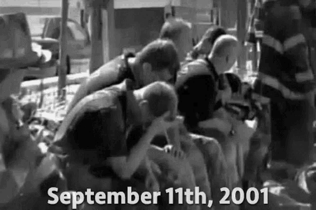 a black and white photo of a group of people sitting next to each other on september 11th , 2001 .