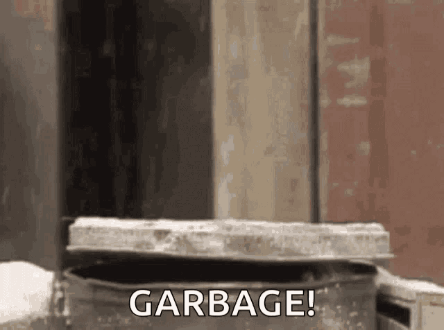 a garbage can with the word garbage written on it is sitting in front of a building .