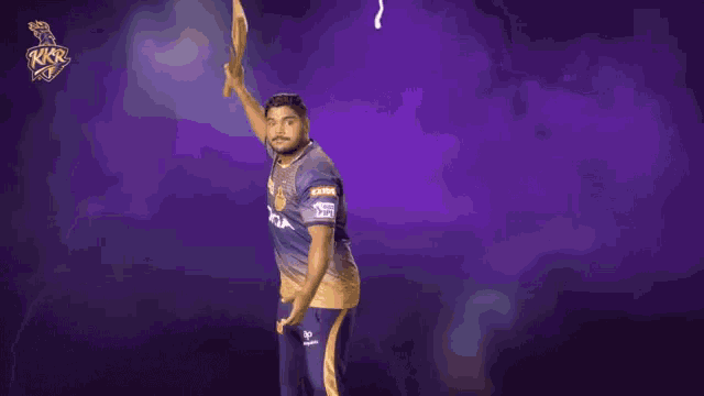 a man holding a cricket bat in front of a purple background with the letters rkr on it