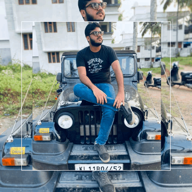 a man wearing a superdry t-shirt sits on the hood of a black jeep