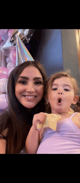 a woman and a little girl are posing for a picture