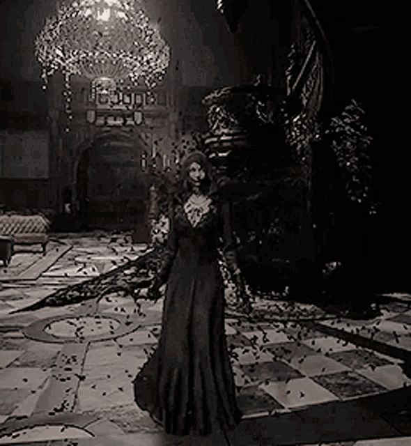 a woman in a long black dress is standing in a dark room with a chandelier .