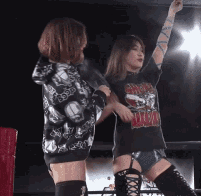 two women in a wrestling ring one wearing a t-shirt that says ' crow ' on it