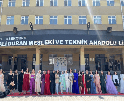 a group of women standing in front of a building that says aliduran mesleki ve teknik anadolu