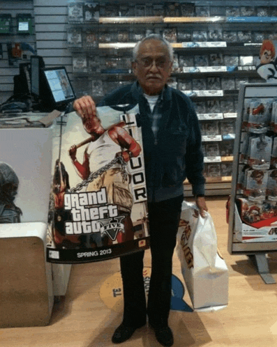 a man is holding a grand theft auto 5 poster