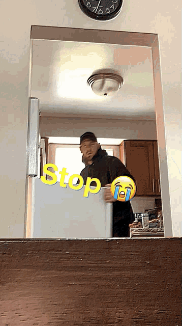 a man standing in front of a refrigerator with stop written on it
