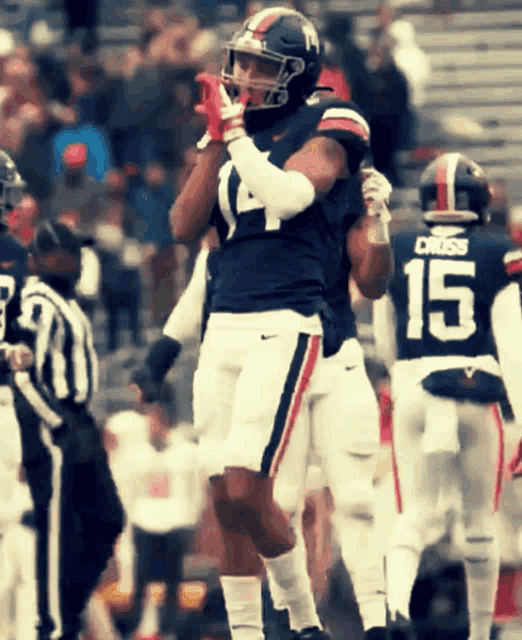 a football player wearing a number 15 jersey stands on the field