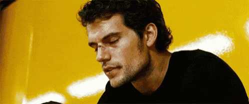 a close up of a man 's face with a black shirt and a yellow background .