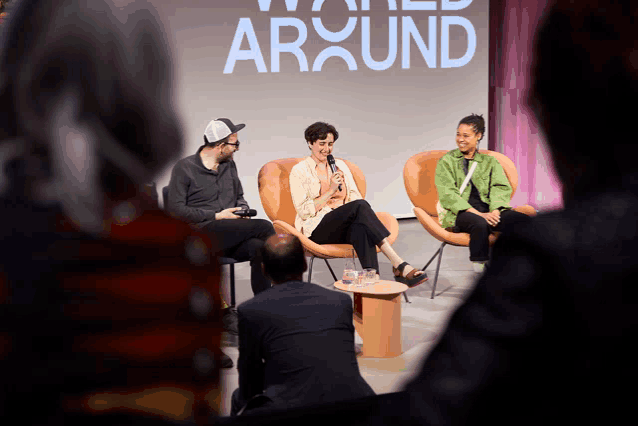 a group of people are sitting in front of a screen that says around