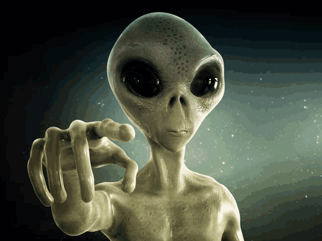 a gray alien is pointing at the camera with his finger