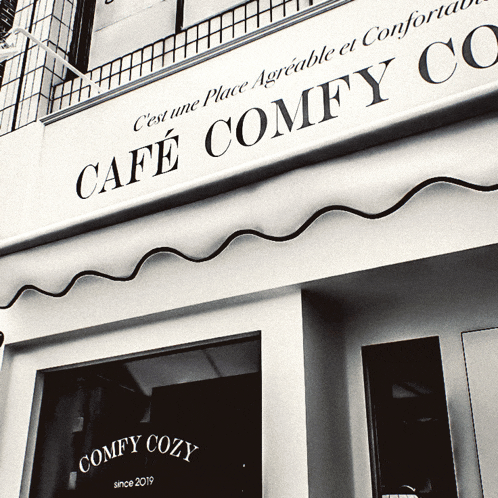 a black and white photo of the front of cafe comfy cozy