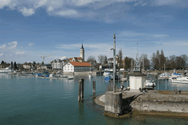 boats are docked in a harbor with a church in the distance