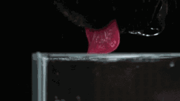 a close up of a person 's tongue sticking out of a glass of water