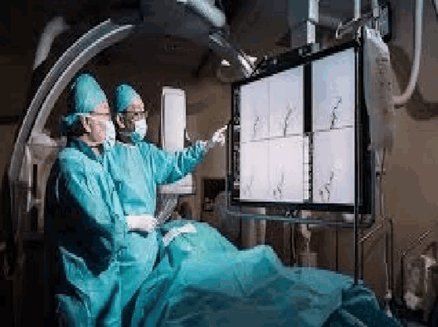 two surgeons are operating on a patient in an operating room .