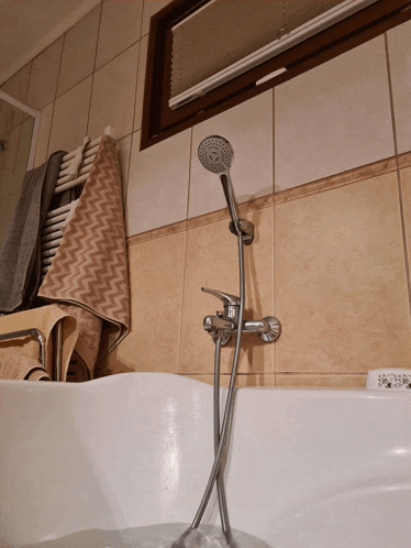 a bathtub with a shower head attached to the side