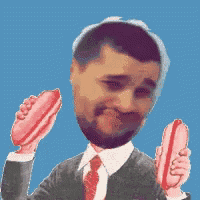 a man in a suit and tie holds two hot dogs in his hands